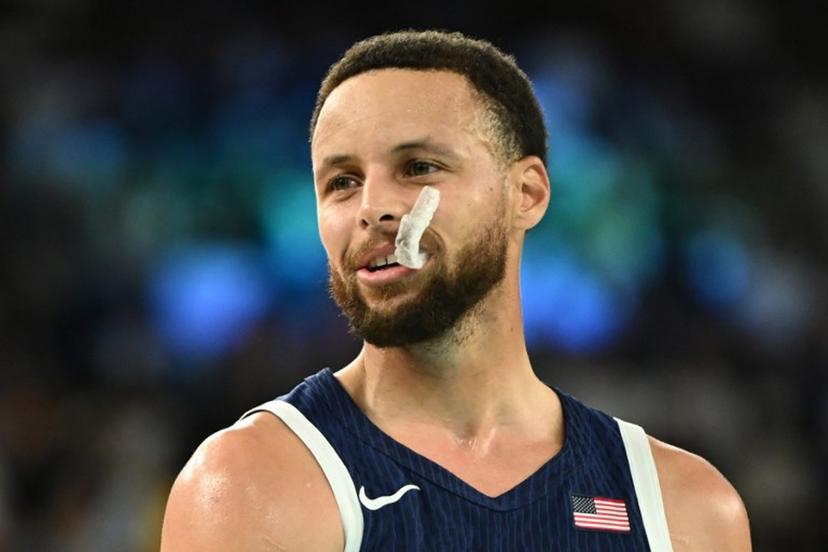USA's #04 Stephen Curry looks on, with his dental protection displaced, in the men's quarterfinal basketball match between Brazil and the USA during the Paris 2024 Olympic Games at the Bercy  Arena in Paris on August 6, 2024.  Aris MESSINIS / AFP