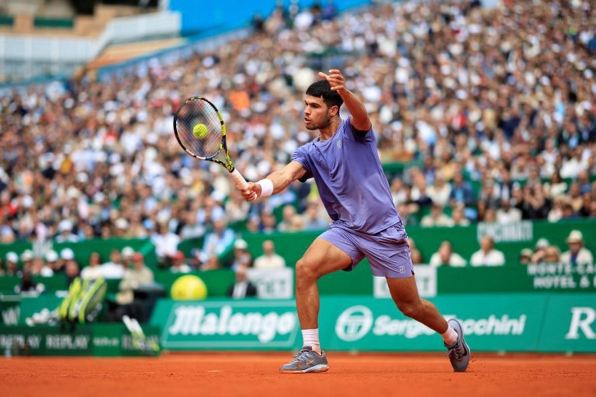 Spain's Carlos Alcaraz plays a backhand return to Spain's Alejandro Davidovich Fokina during the Monte Carlo ATP Masters Series Tournament semi-final tennis match at the Monte Carlo Country Club in Roquebrune-Cap-Martin on April 12, 2025. Valery HACHE / AFP