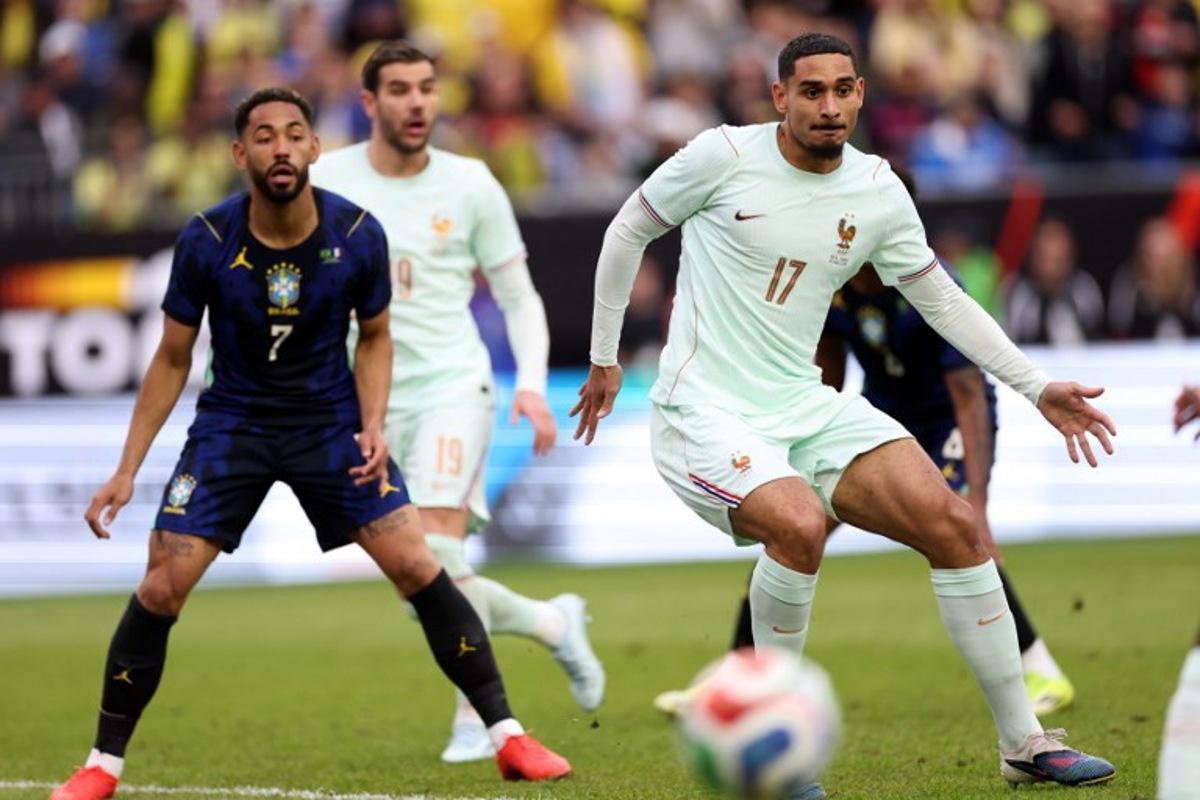 France's defender #17 Maxence Lacroix and Brazil's forward #07 Matheus Cunha look on during a friendly football match between Brazil and France at Gillette Stadium in Foxborough, Massachusetts, on March 26, 2026.  FRANCK FIFE / AFP
