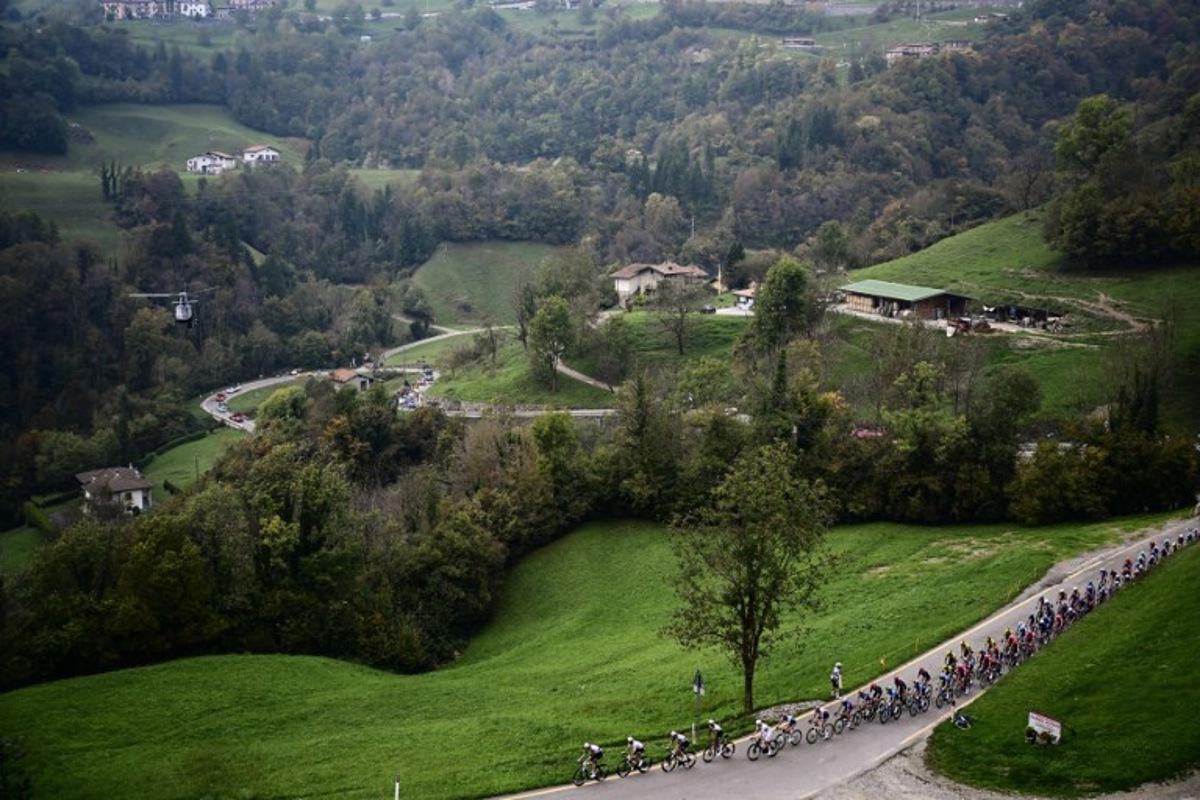 The pack of riders (peloton) cycles in the Zambla Alta ascent during the 119th edition of the Giro di Lombardia (Tour of Lombardy), a 238km cycling race from Como to Bergamo on October 11, 2025.  Marco BERTORELLO / AFP