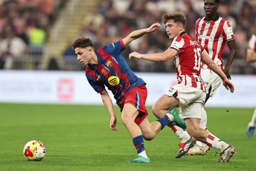 Barcelona's Spanish midfielder #16 Fermin Lopez runs for the ball with Athletic Bilbao's Spanish midfielder #18 Mikel Jauregizar Alboniga during the Spanish Supercup semi-final football match between FC Barcelona and Athletic Bilbao at King Abdullah Sports City in Jeddah on January 7, 2026.  Fadel SENNA / AFP