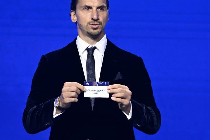 AC Milan's Swedish senior advisor Zlatan Ibrahimovic holds up the slip of Club Brugge during the draw ceremony for the group stage of the 2025-2026 UEFA Champions League football tournament, at the Grimaldi Forum in Monaco on August 28, 2025.  Frederic DIDES / AFP