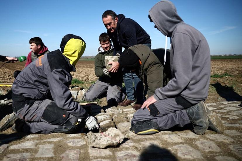 Workers repair cobblestones on the route of the Paris-Roubaix cycling race, in presence of race director Thierry Gouvenou (C), near Arenberg, on April 4, 2023, ahead of this week-end's women and men races.  Anne-Christine POUJOULAT / AFP