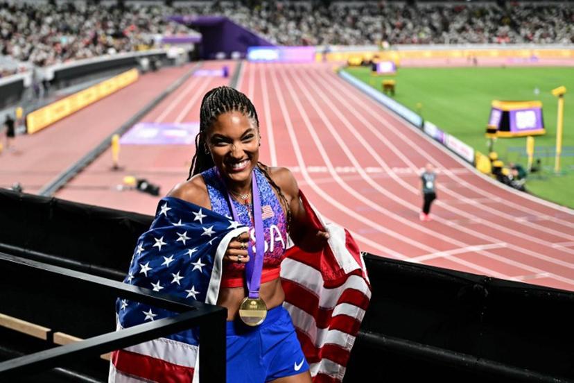 US' athlete Tara Davis-Woodhall celebrates with her country's flag after winning the women's long jump final during the World Athletics Championships in Tokyo on September 14, 2025.  Yuichi YAMAZAKI / AFP