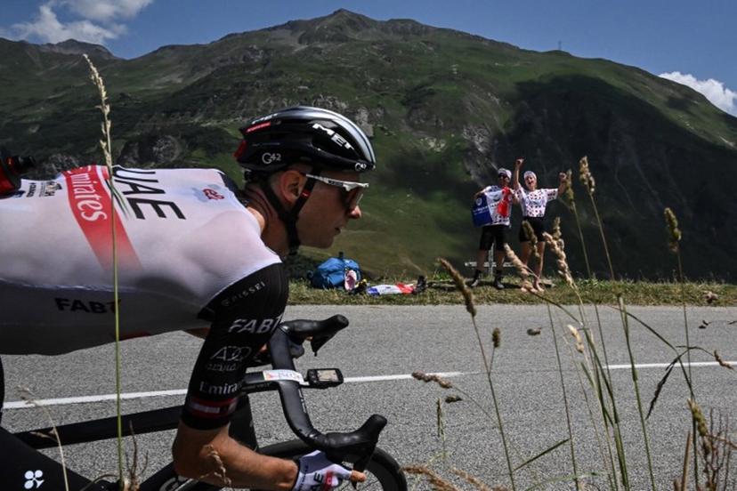 Spectators cheer along the roadside as UAE Team Emirates' Austrian rider Felix Grossschartner cycles past during the 17th stage of the 110th edition of the Tour de France cycling race, 166 km between Saint-Gervais Mont-Blanc and Courchevel, in the French Alps, on July 19, 2023.  Marco BERTORELLO / AFP