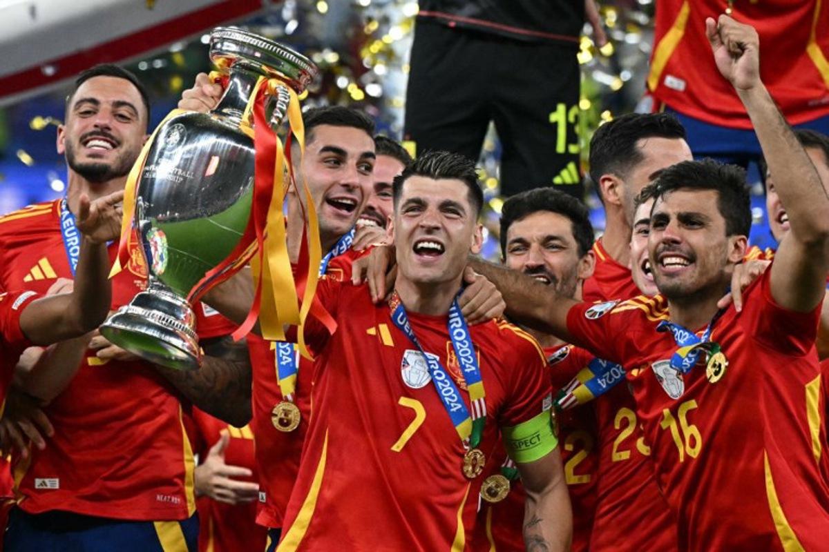 Spain's forward #07 Alvaro Morata rises the trophy next to Spain's midfielder #16 Rodri (R) after winning the UEFA Euro 2024 final football match between Spain and England at the Olympiastadion in Berlin on July 14, 2024. JAVIER SORIANO / AFP