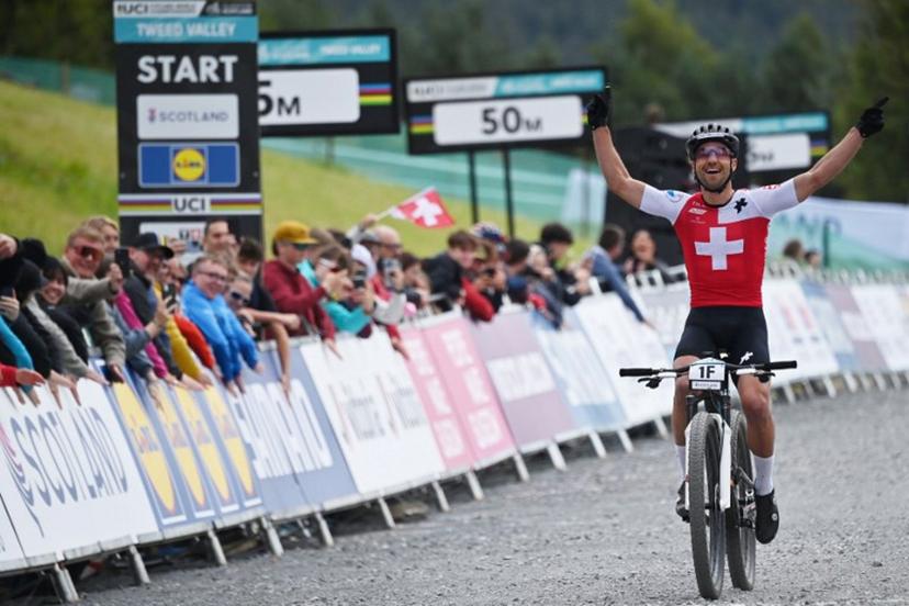 Switzerland's Nino Schurter celebrates winning gold as he crosses the line in the mixed team relay mountain bike cross-country race at the Cycling World Championships in Glentress Forest, Scotland on August 9, 2023.  ANDY BUCHANAN / AFP