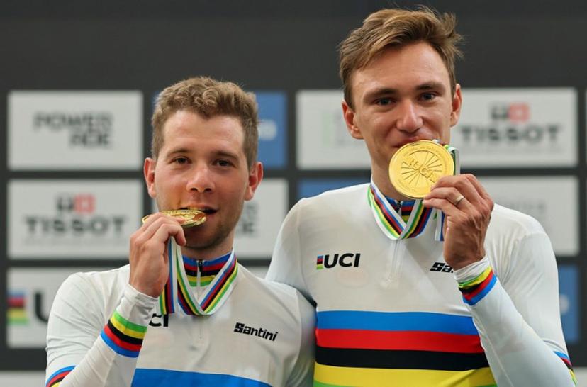 Belgium's Fabio Van den Bossche (L) and Lindsay De Vylder bite their gold medals during the men's madison 50km event award ceremony at the 2025 UCI Track World Championships, in the Penalolen Velodrome in Santiago, on October 26, 2025.  Javier TORRES / AFP