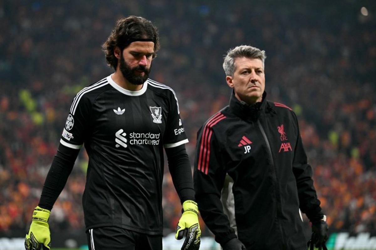 Liverpool's Brazilian goalkeeper #01 Alisson (L) walks off the pitch injured as he is substituted during the UEFA Champions League first round day 2 football match between Galatasaray (TUR) and Liverpool (ENG) at the Ali Sami Yen Spor Kompleksi in Istanbul on September 17, 2025.  Ozan KOSE / AFP