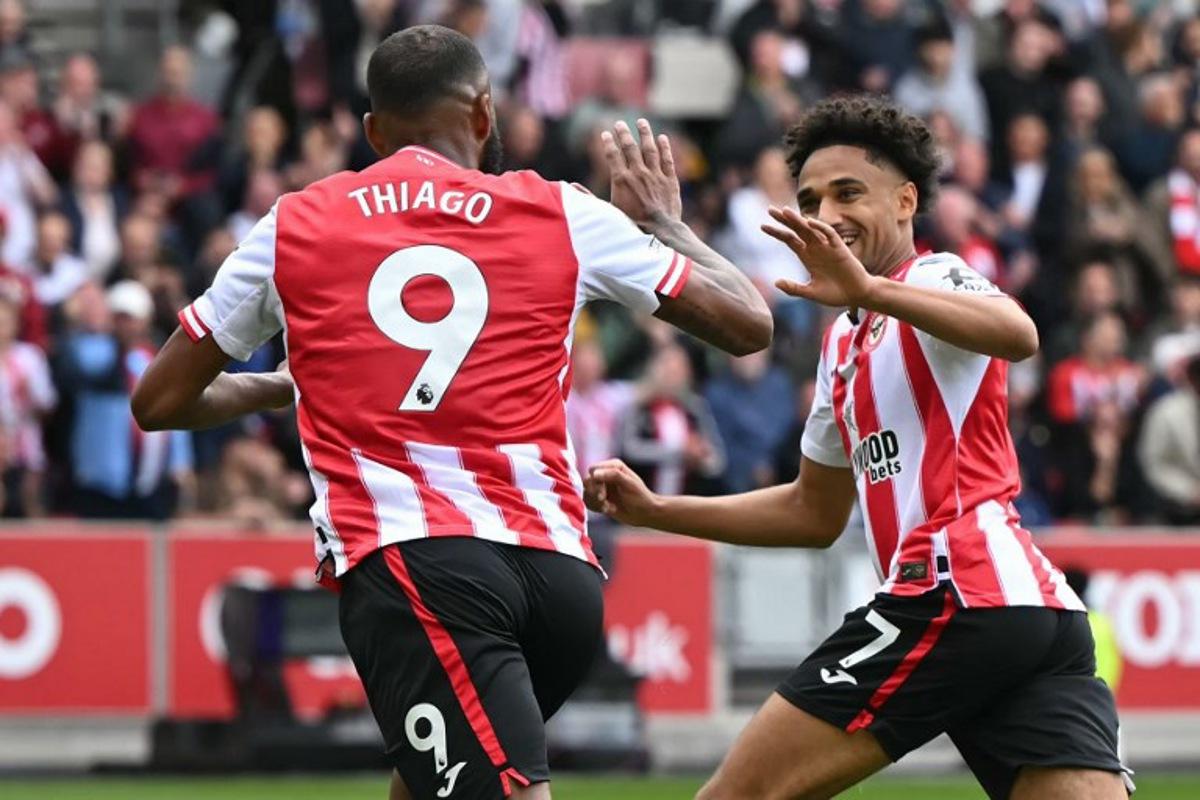 Brentford's Brazilian striker #09 Igor Thiago celebrates with Brentford's German midfielder #07 Kevin Schade after scoring the opening goal of the English Premier League football match between Brentford and Manchester United at the Gtech Community Stadium in London on September 27, 2025.  JUSTIN TALLIS / AFP