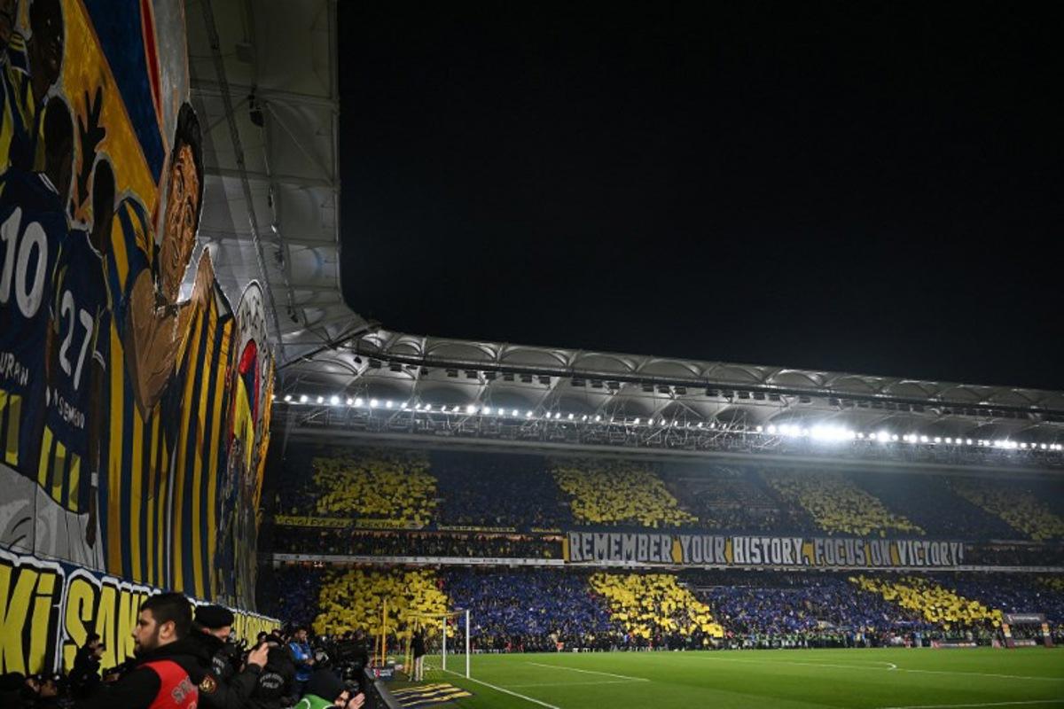 Fenerbahce's fans cheers for their team before the Turkish Super lig football match between Fenerbahce and Galatasaray at the Fenerbahce Sukru Saracoglu stadium in Istanbul, on December 1, 2025.  Ozan KOSE / AFP