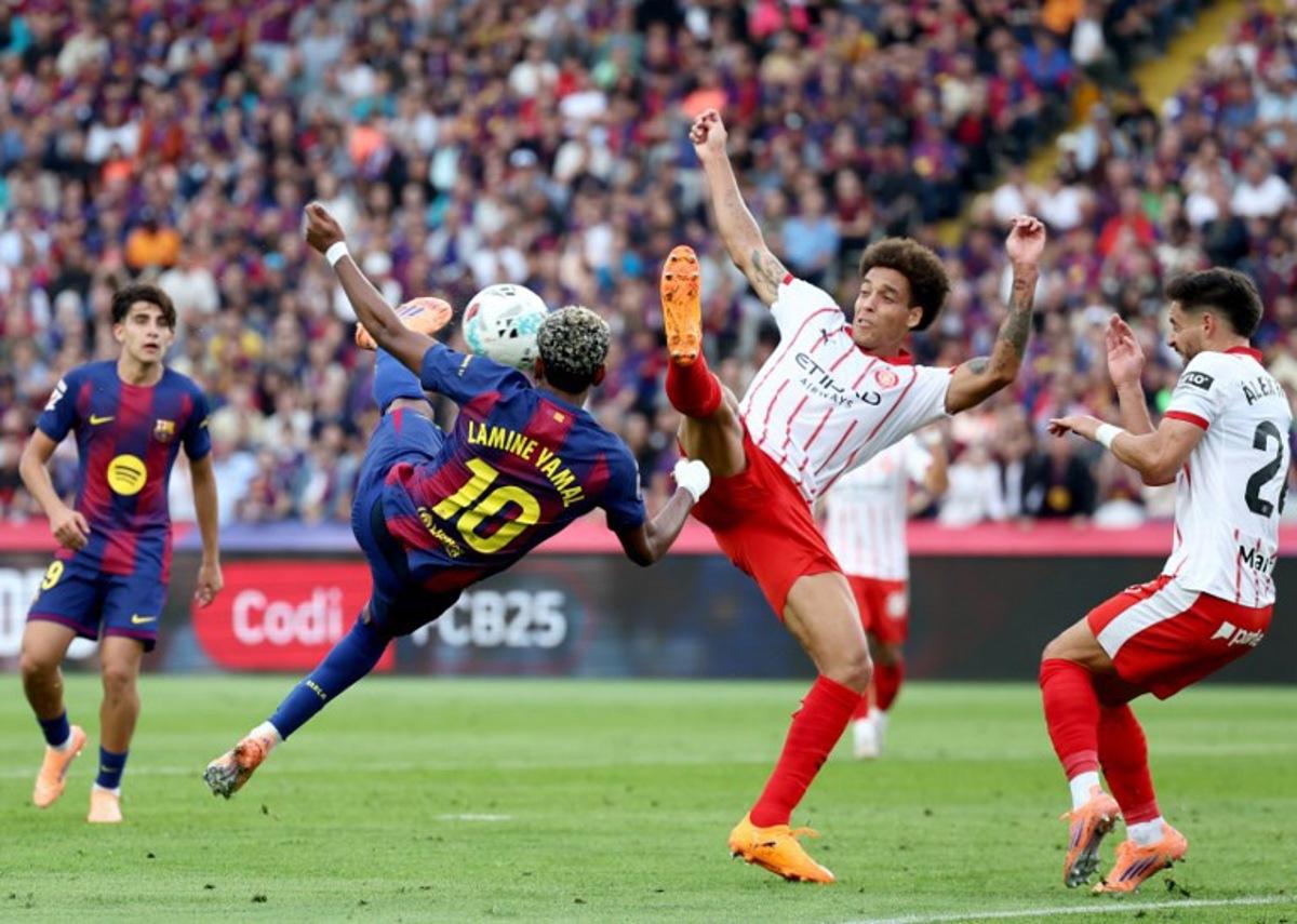 Barcelona's Spanish forward #10 Lamine Yamal fights for the ball with Girona's Belgian defender #20 Axel Witsel during the Spanish league football match between FC Barcelona and Girona FC at Estadi Olimpic Lluis Companys in Barcelona on October 18, 2025.  Josep LAGO / AFP