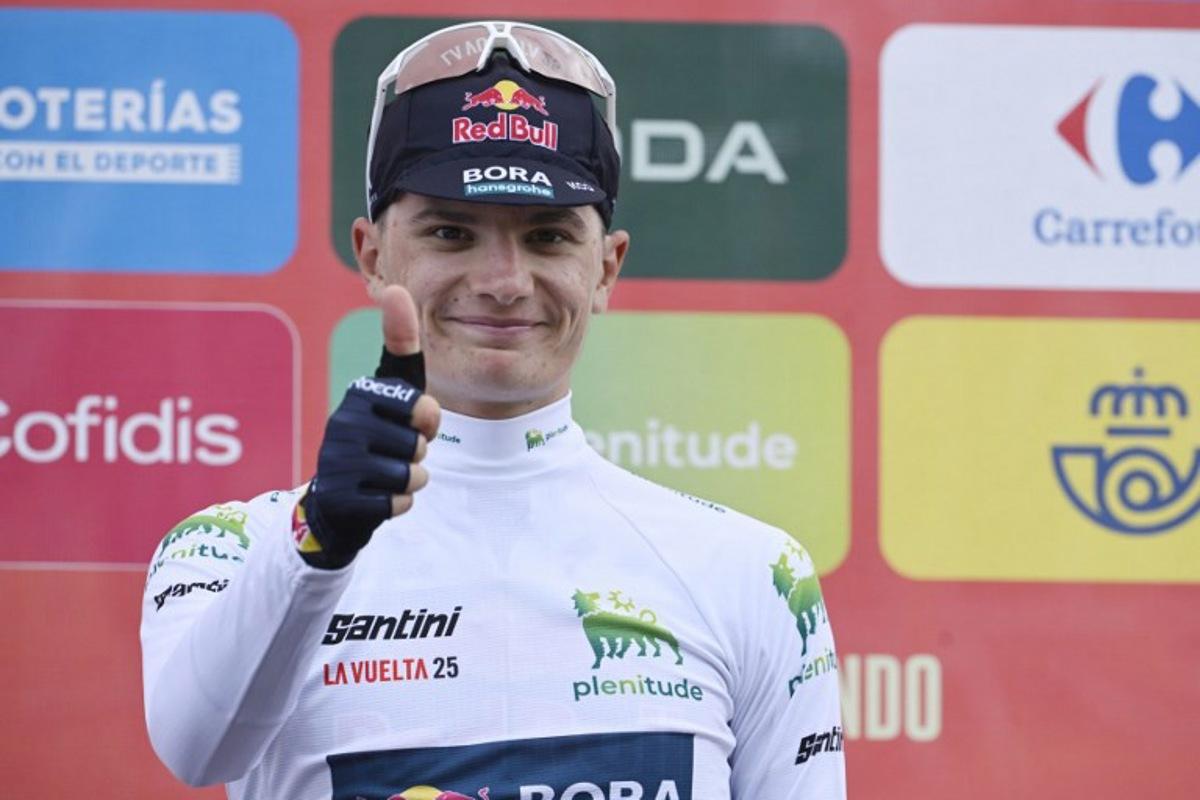 Team Bora's Italian rider Giulio Pellizzari celebrates on the podium retaining the best youth white jersey after the 14th stage of the Vuelta a Espana cycling tour, a 135 km race between Aviles and La Farrapona in Somiedo, on September 6, 2025.    Miguel RIOPA / AFP