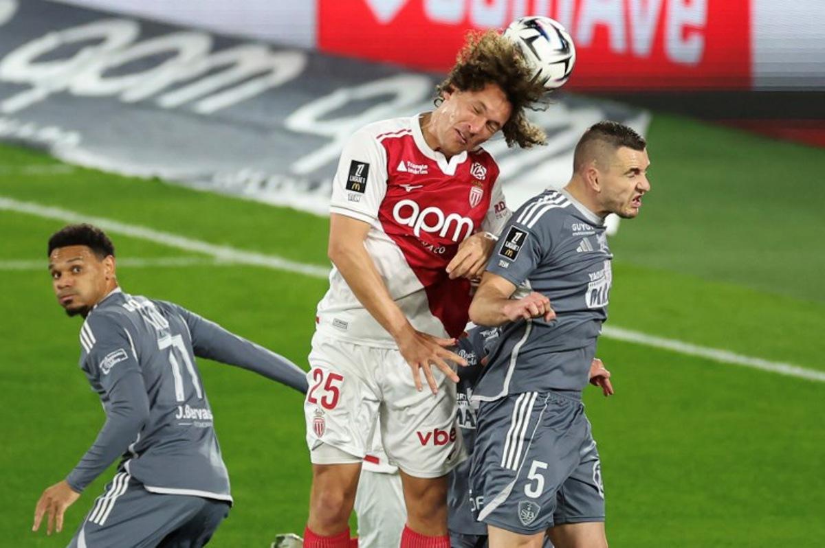 Monaco's Belgian defender #25 Wout Faes (C) fights for the ball with Brest's French defender #05 Brendan Chardonnet (R) during the French L1 football match between AS Monaco and Stade Brestois 29 at the Stade Louis II in the Principality of Monaco on March 14, 2026.  Valery HACHE / AFP