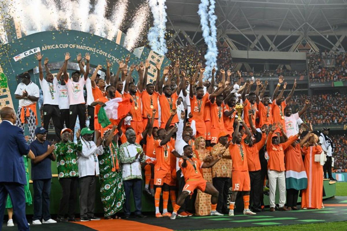 Ivory Coast's forward #15 Max-Alain Gradel lifts the Africa Cup of Nations trophy on the podium after Ivory Coast won the Africa Cup of Nations (CAN) 2024 final football match between Ivory Coast and Nigeria at Alassane Ouattara Olympic Stadium in Ebimpe, Abidjan on February 11, 2024.  Issouf SANOGO / AFP