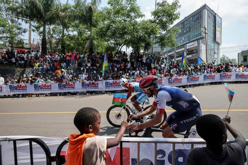 Mongolian rider Tegshbayar Batsaikhan (L) and French rider Julian Alaphilippe (R) competes in the men's Elite road race cycling event during the UCI 2025 Road World Championships, in Kigali, on September 28, 2025.  Anne-Christine POUJOULAT / AFP