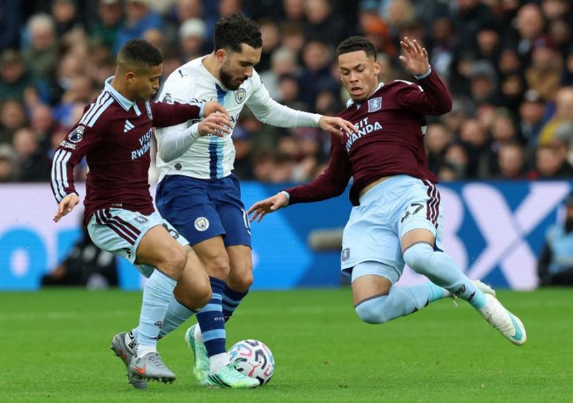 Aston Villa's Brazilian striker #47 Alysson (R) dives to tackle Manchester City's French midfielder #10 Rayan Cherki during the English Premier League football match between Aston Villa and Manchester City at Villa Park in Birmingham, central England on October 24, 2026.  Darren Staples / AFP