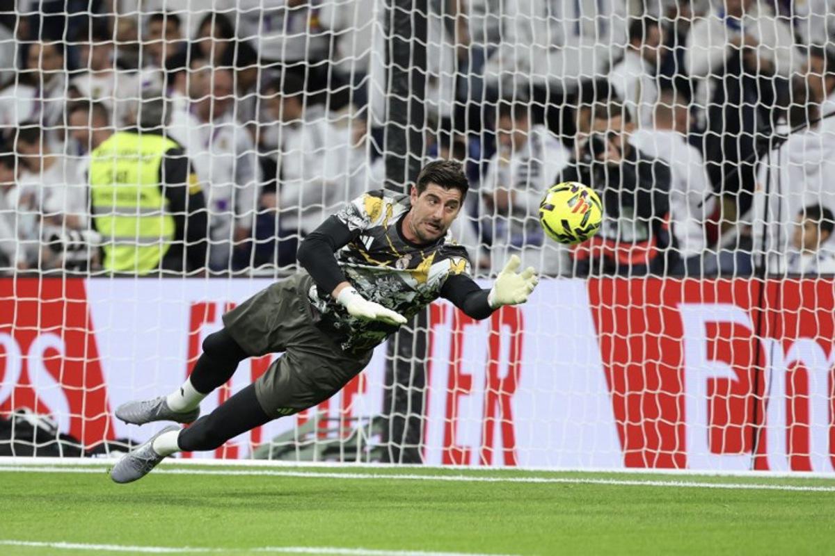 Real Madrid's Belgian goalkeeper #01 Thibaut Courtois warms up before the start of the Spanish league football match between Real Madrid CF and RC Celta de Vigo at the Santiago Bernabeu Stadium in Madrid on December 7, 2025.  Thomas COEX / AFP