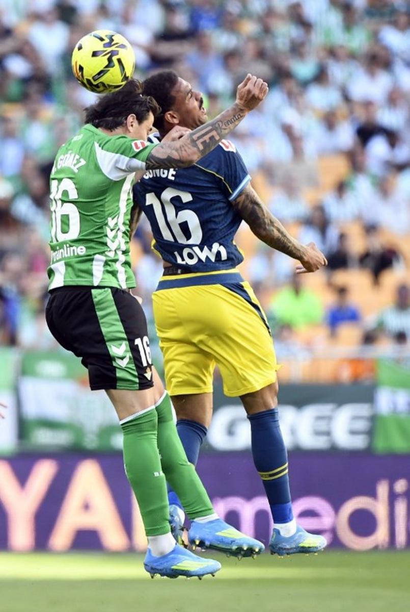 Real Betis' Argentinian defender #16 Valentin Gomez (L) and Espanyol's Belgian midfielder #16 Cyril Ngonge vie for a header during the Spanish league football match between Real Betis and RCD Espanyol at Benito Villamarin Stadium in Seville on April 4, 2026.  CRISTINA QUICLER / AFP