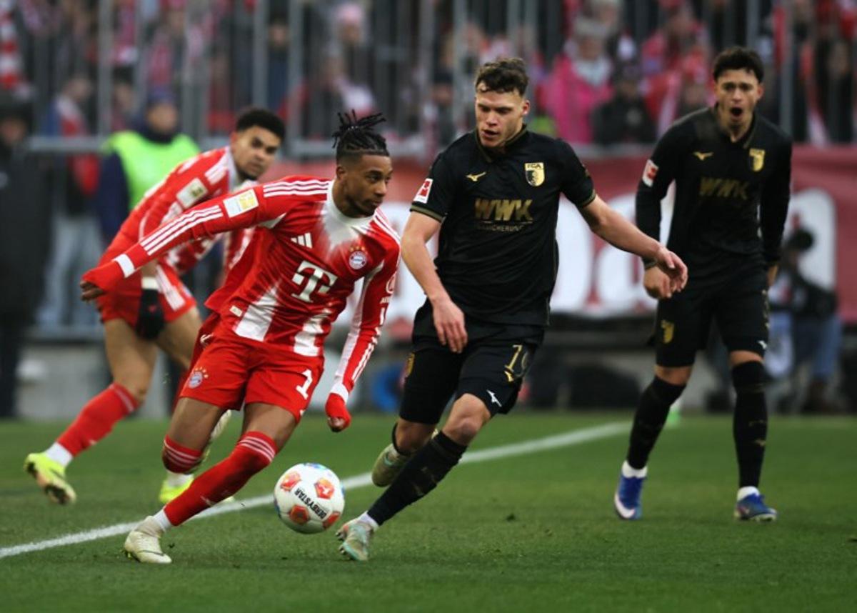 Bayern Munich's French midfielder #17 Michael Olise and Augsburg's German midfielder #19 Robin Fellhauer vie for the ball during the German first division Bundesliga football match between FC Bayern Munich and FC Augsburg in Munich, southern Germany, on January 24, 2026.  Alexandra BEIER / AFP