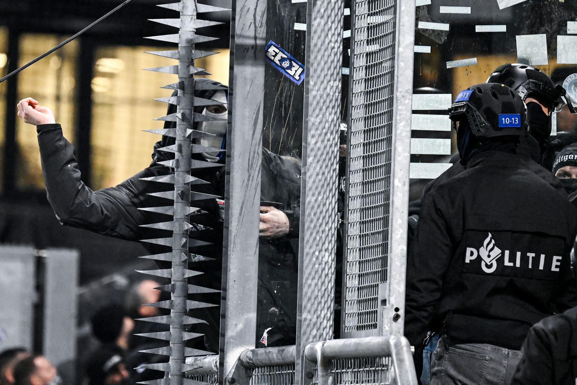 A masked Genk supporter provokes Dutch police ahead of a soccer game between Dutch soccer club FC Utrecht and Belgian KRC Genk, on Thursday 22 January 2026 in Utrecht, Netherlands, the seventh game (out of 8) in the league phase of the UEFA Europa League competition. BELGA PHOTO TOM GOYVAERTS