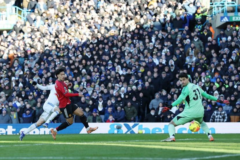 Leeds United's US midfielder #11 Brenden Aaronson (L) scores the opening goal past Manchester United's Belgian goalkeeper #31 Senne Lammens (R) to take the lead 1-0 during the English Premier League football match between Leeds United and Manchester United at Elland Road in Leeds, northern England on January 4, 2026.  Darren Staples / AFP