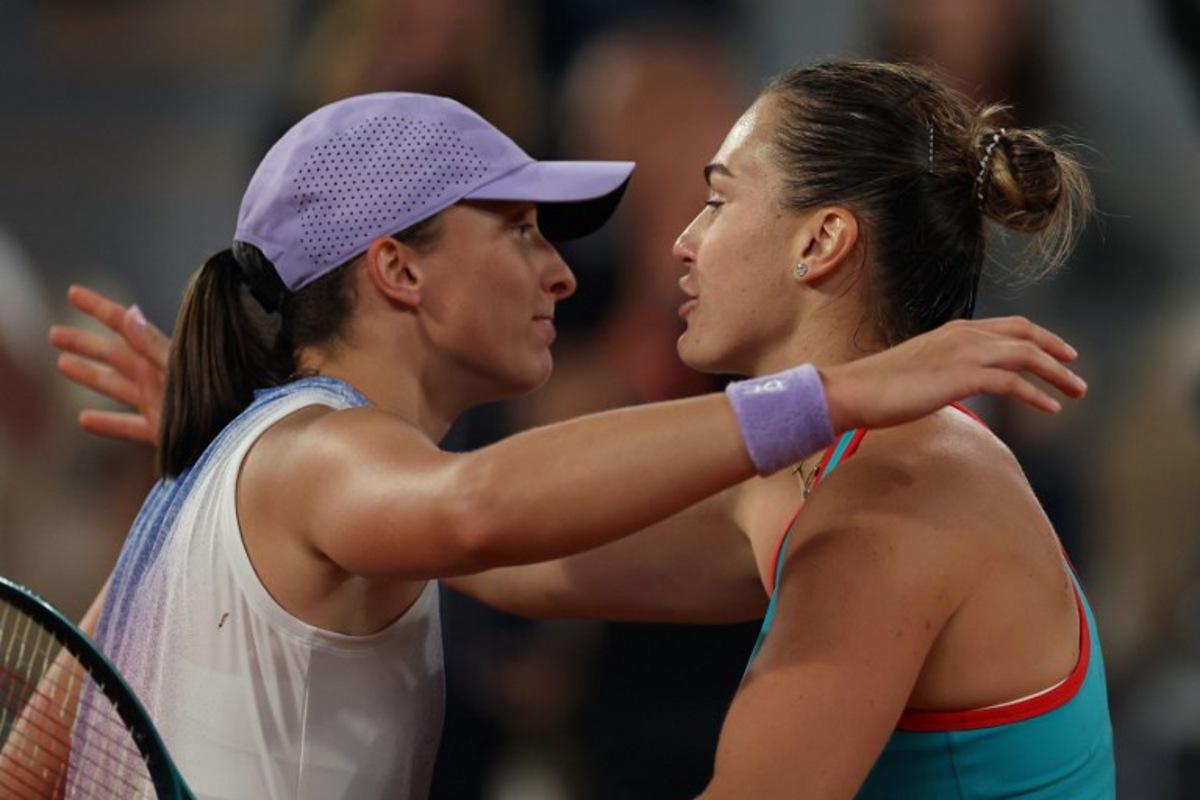 Belarus' Aryna Sabalenka (R) comforts Poland's Iga Swiatek after defeating her in their women's singles semi-final match on day 12 of the French Open tennis tournament on Court Philippe-Chatrier at the Roland-Garros Complex in Paris on June 5, 2025.  Alain JOCARD / AFP
