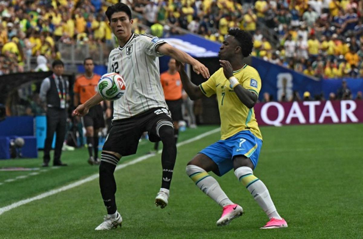 Japan's defender #22 Takehiro Tomiyasu (L) fights for the ball with Brazil's forward #07 Vinicius Junior during the 2026 World Cup round of 32 football match between Brazil and Japan at the Houston Stadium in Houston on June 29, 2026.   RONALDO SCHEMIDT / AFP