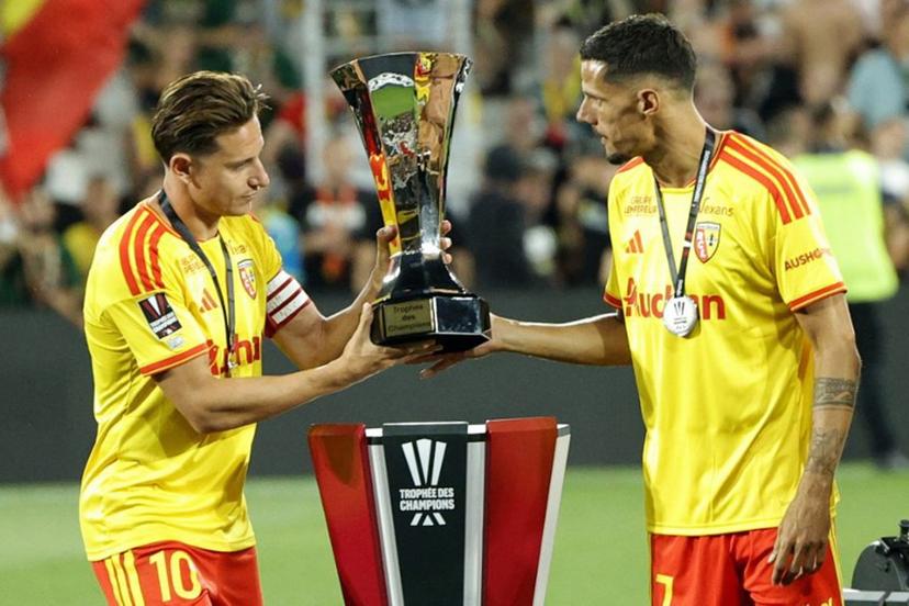 Lens' French forward #10 Florian Thauvin (L) and Lens' French forward #07 Florian Sotoca take the championship trophy to celebrate with teammates after winning the French Super Cup (Trophee des Champions) football match between RC Lens and Paris Saint-Germain (PSG) at the Stade Bollaert-Delelis in Lens, northern France on August 16, 2026.  GEOFFROY VAN DER HASSELT / AFP