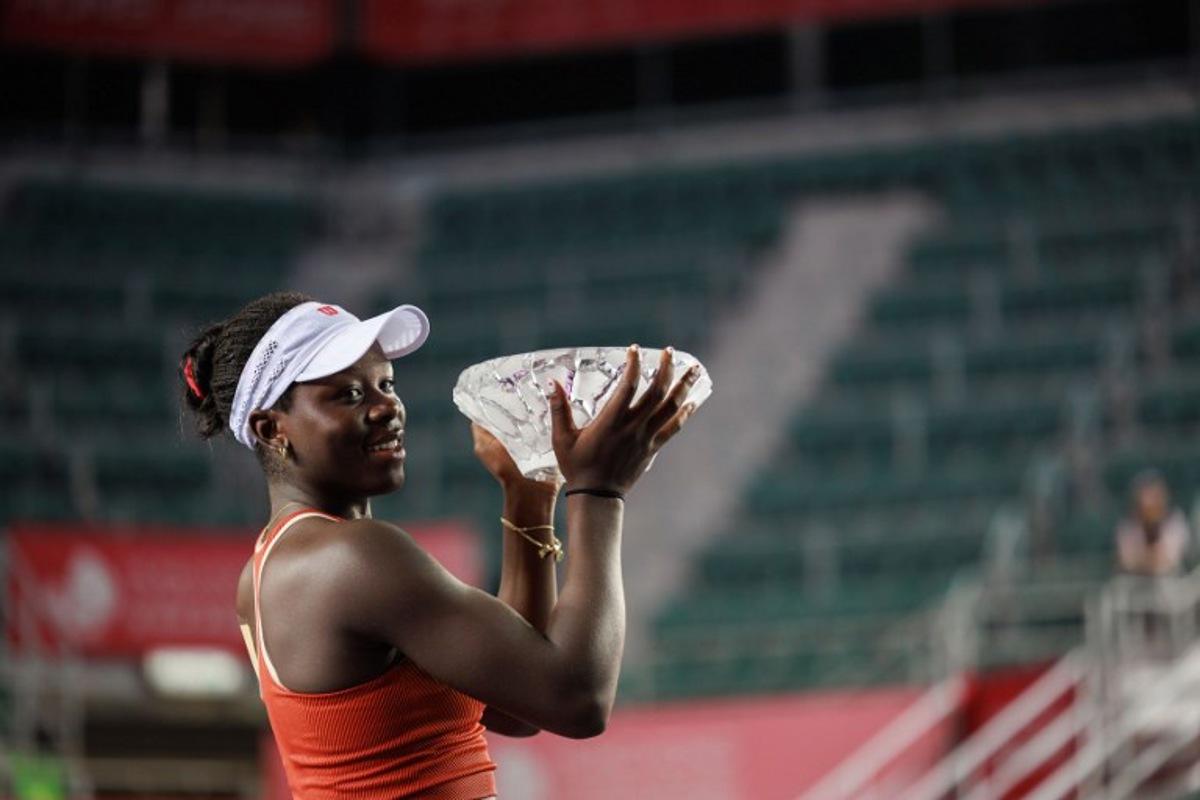 Victoria Mboko of Canada holds the trophy after winning against Cristina Bucsa of Spain in the women's singles final of the Hong Kong Tennis Open in Hong Kong on November 2, 2025.  May JAMES / AFP