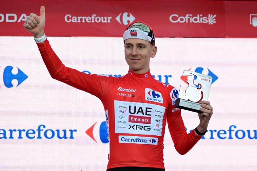 UAE Team Emirates - XRG team's Slovenian rider Tadej Pogacar celebrates on the podium wearing the overall leader's red jersey, after winning the first stage of the Vuelta a Espana 2026, a 9,4 km time-trial between Monaco and Monaco on August 22, 2026.  Miguel MEDINA / AFP