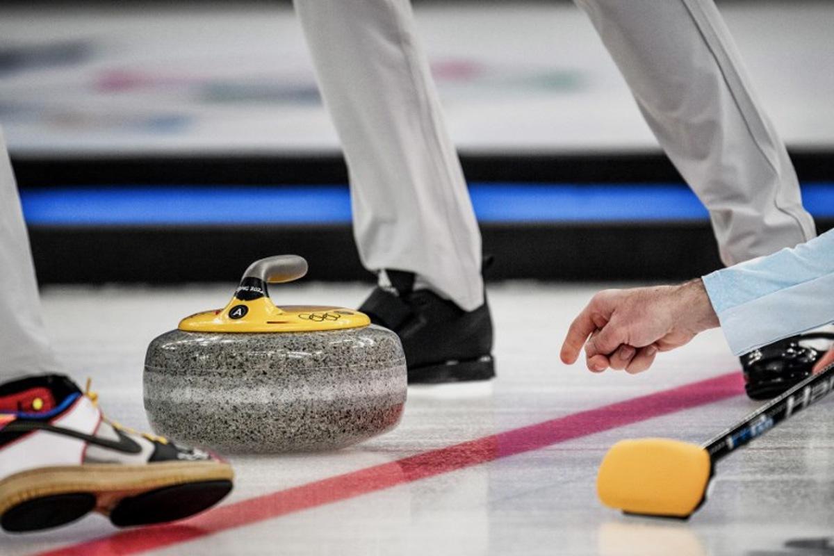 USA's John Shuster curls the stone during the men's bronze medal game of the Beijing 2022 Winter Olympic Games curling competition between Canada and USA at the National Aquatics Centre in Beijing on February 18, 2022.  Jeff PACHOUD / AFP