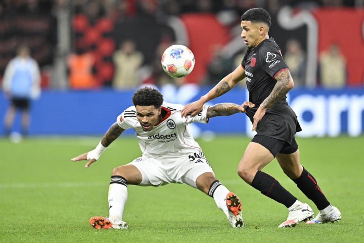 Frankfurt's German-Nigerian defender #34 Nnamdi Collins (L) and Bayer Leverkusen's Argentinian midfielder #06 Ezequiel Fernandez vie for the ball during the German first division Bundesliga football match between Bayer 04 Leverkusen and Eintracht Frankfurt in Leverkusen, western Germany on September 12, 2025.  INA FASSBENDER / AFP