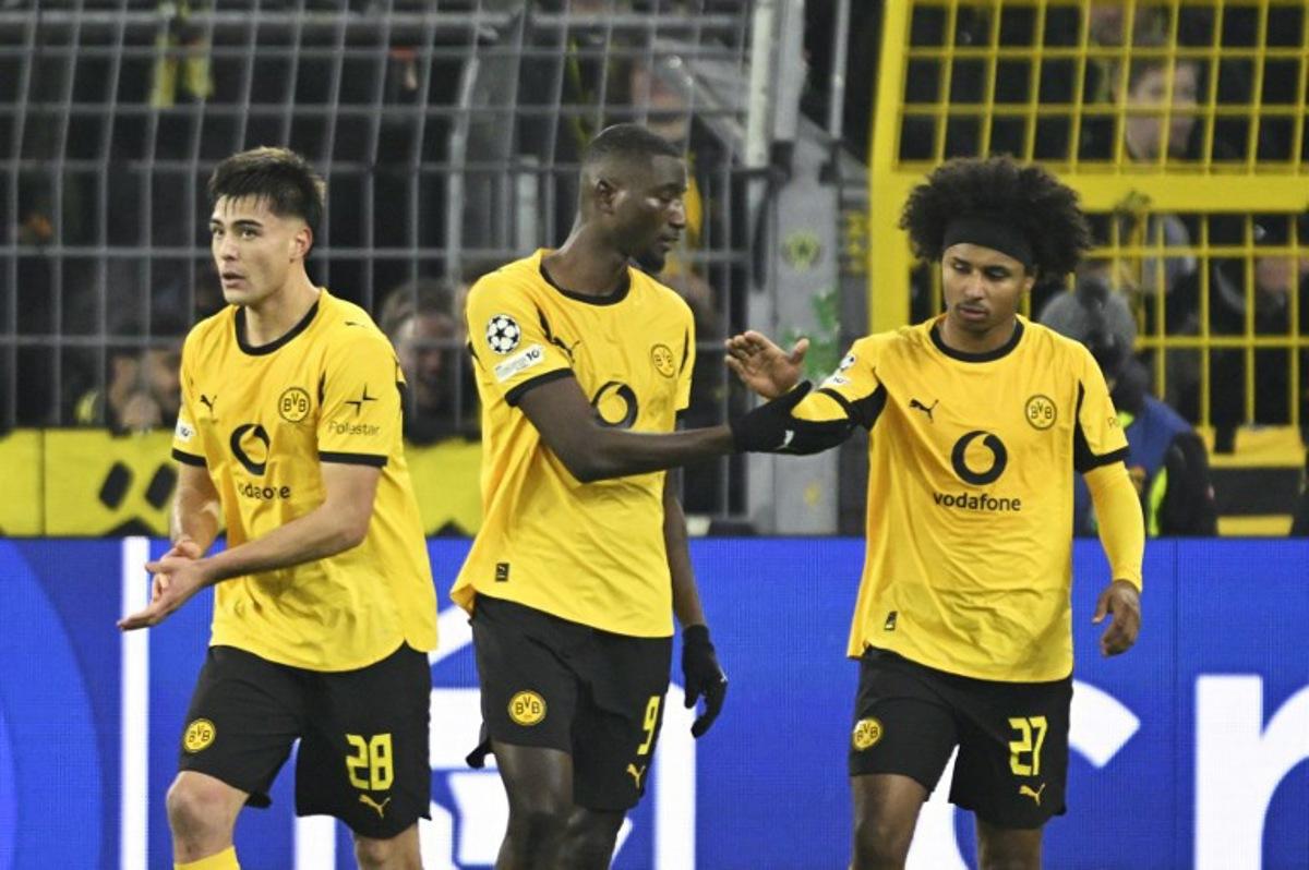 Dortmund's Guinean forward #09 Serhou Guirassy (C) celebrates with Dortmund's German forward #27 Karim Adeyemi (R) and Dortmund's Argentinian defender #28 Aaron Anselmino after scoring the opening 1-0 goal during the UEFA Champions League league phase day 5 football match between Borussia Dortmund and Villareal CF in Dortmund, on November 25, 2025.  INA FASSBENDER / AFP