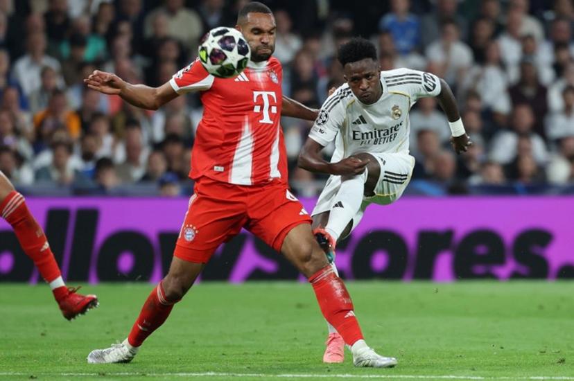 Real Madrid's Brazilian forward #07 Vinicius Junior (R) kicks past Bayern Munich's German defender #04 Jonathan Tah during the UEFA Champions League quarter final first leg football match between Real Madrid CF and FC Bayern Munich at Santiago Bernabeu Stadium in Madrid on April 7, 2026.  Thomas COEX / AFP