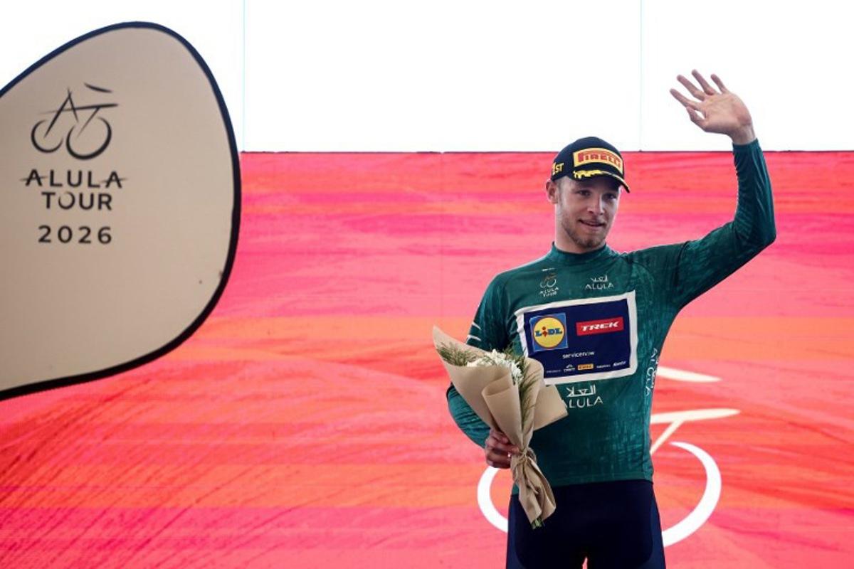 Lidl-Trek cycling team's Italian rider Jonathan Milan celebrates on the podium after winning the first stage of the AlUla Tour cycling race, a 158 km race started and finished in the Saudi desert city of AlUla, on January 27, 2026.  Anne-Christine POUJOULAT / AFP