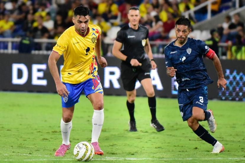 Colombian forward Radamel Falcao (L) runs with the ball past former football player Fabian Vargas (R) during the Legendary Captains match in tribute to Mario Yepes at the Pascual Guerrero stadium in Cali, Colombia on December 20, 2025.  Edwin PIPICANO / AFP