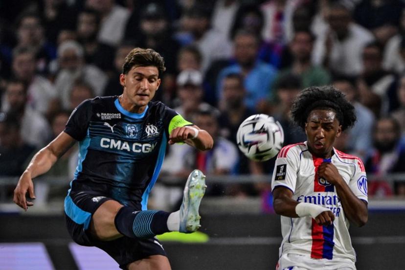 Marseille's Argentinian defender #05  Leonardo Balerdi (L) fights for the ball with Lyon's Belgium forward #11 Malick Fofana during the French L1 football match between Olympique Lyonnais (OL) and Olympique Marseille (OM) at the Groupama Stadium in Decines-Charpieu, central-eastern France, on August 31, 2025.  OLIVIER CHASSIGNOLE / AFP