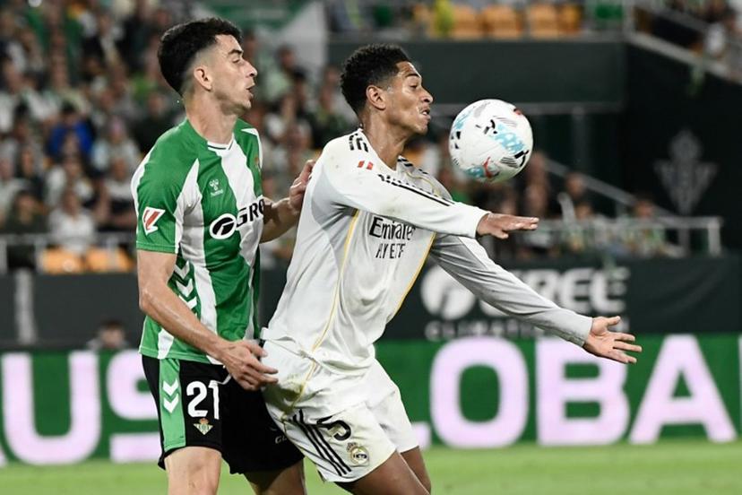 Real Madrid's English midfielder #05 Jude Bellingham (R) vies for the ball with Real Betis' Spanish midfielder #21 Marc Roca during the Spanish league football match between Real Betis and Real Madrid CF at the La Cartuja stadium in Seville on April 24 , 2026.  CRISTINA QUICLER / AFP