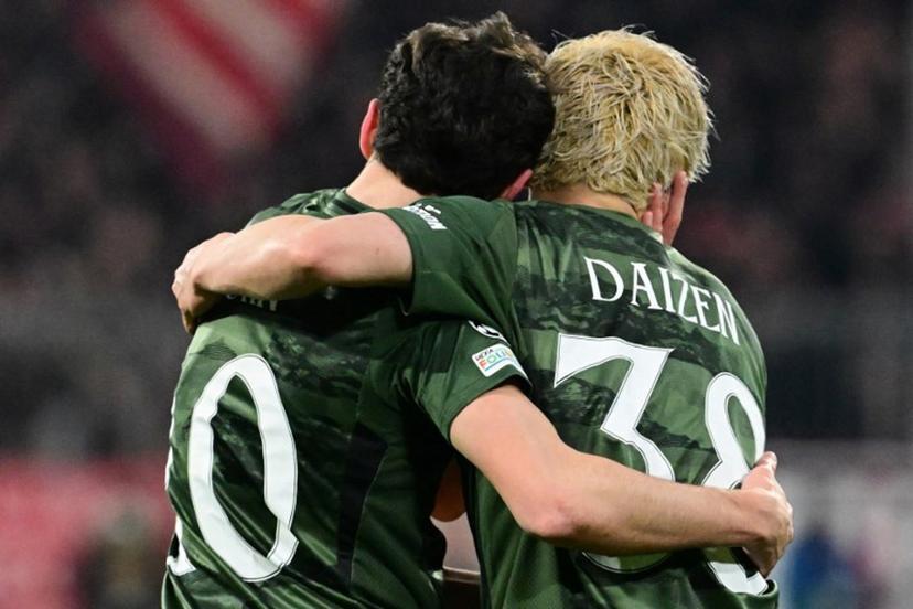 Celtic's German forward #10 Nicolas Kuehn (L) celebrates scoring the opening goal with his teammate Celtic's Japanese forward #38 Daizen Maeda during the UEFA Champions League second-leg, knockout phase play-off match FC Bayern Munich vs Celtic on February 18, 2025 in Munich.  Tobias SCHWARZ / AFP