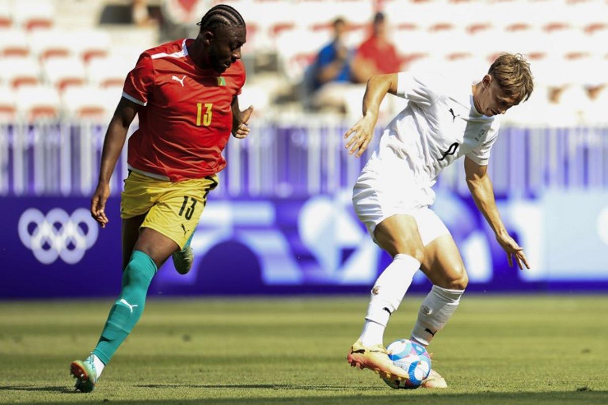 Guinea's defender #13 Madiou Keita (L) and New Zealand's forward #09 Ben Waine vie for the ball in the men's group A football match between Guinea and New Zealand during the Paris 2024 Olympic Games at the Nice Stadium in Nice on July 24, 2024.  Valery HACHE / AFP