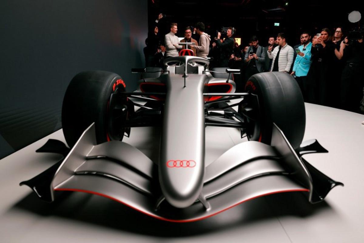 Massimo Frascella (C), Chief Creative Officer at AUDI AG, together with Kick Sauber's German driver Nico Hulkenberg (L) and Kick Sauber's Brazilian driver Gabriel Bortoleto (R) unveils the F1 car of the Audi F1 factory team set to compete in the Formula One starting in the 2026 season in Munich, southern Germany on November 12, 2025.  Alexandra BEIER / AFP