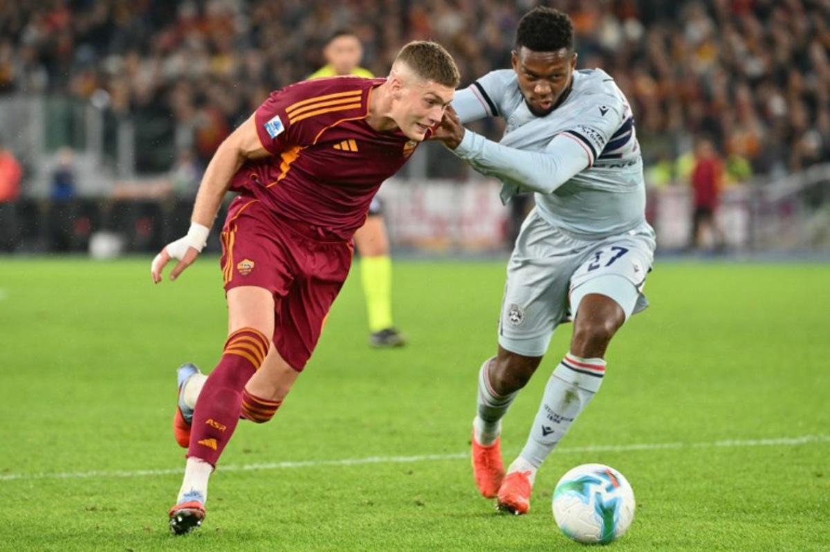 Roma's Ukrainian forward #09 Artem Dovbyk fights for the ball with Udinese's Belgian defender #27 Christian Kabasele during the Italian Serie A football match between AS Roma and Udinese at the Olympic Stadium in Rome on November 9, 2025.  Alberto PIZZOLI / AFP
