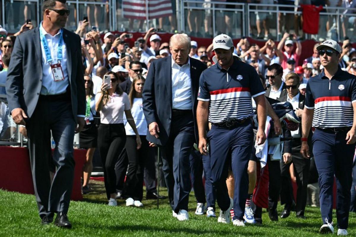 US President Donald Trump walks with pro-golfer Bryson DeChambeau (2R) as he attends the 45th Ryder Cup golf competition at Bethpage Black Course in Farmingdale, New York, on September 26, 2025.  Mandel NGAN / POOL / AFP