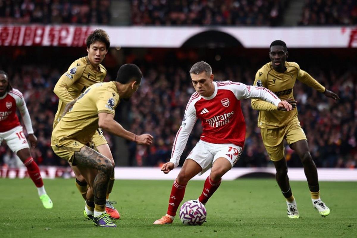 Arsenal's Belgian midfielder #19 Leandro Trossard (C) vies with Crystal Palace's Colombian defender #02 Daniel Munoz (L) during the English Premier League football match between Arsenal and Crystal Palace at the Emirates Stadium in London on October 26, 2025.   HENRY NICHOLLS / AFP