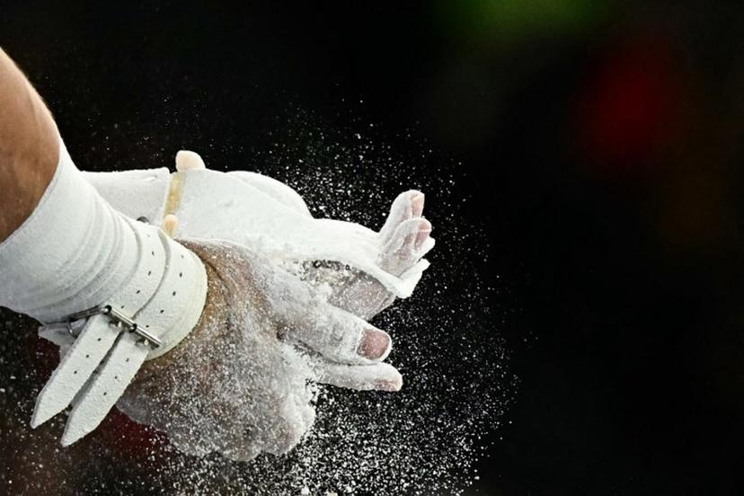 US' Brody Malone puts chalk on his hands before competing in the horizontal bar event of the artistic gymnastics men's qualification during the Paris 2024 Olympic Games at the Bercy Arena in Paris, on July 27, 2024.  Gabriel BOUYS / AFP
