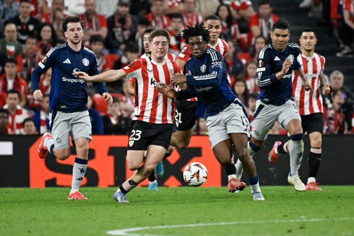 Athletic Bilbao's Spanish midfielder #23 Mikel Jauregizar Alboniga (L) challenges Manchester United's Danish defender #13 Patrick Dorgu for the ball during the UEFA Europa League semi final first leg football match between Athletic Club Bilbao and Manchester United at the San Mames stadium in Bilbao, on May 1, 2025.  ANDER GILLENEA / AFP
