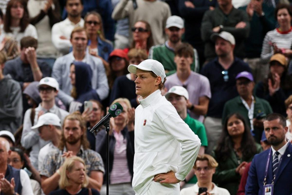 Italy's Jannik Sinner addresses the crowd after winning following the withdrew of Bulgaria's Grigor Dimitrov due to injury at the end of their men's singles fourth round tennis match on the eighth day of the 2025 Wimbledon Championships at The All England Lawn Tennis and Croquet Club in Wimbledon, southwest London, on July 7, 2025.  Adrian Dennis / AFP
