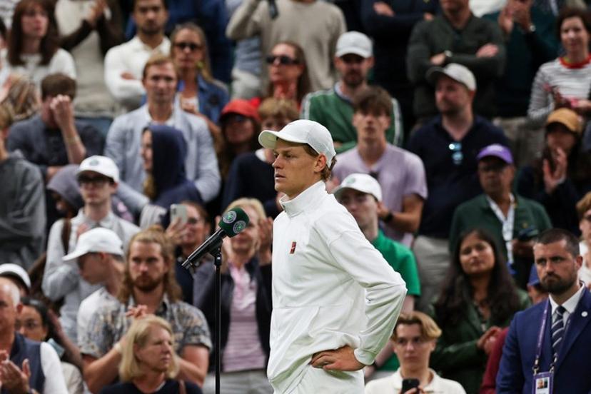 Italy's Jannik Sinner addresses the crowd after winning following the withdrew of Bulgaria's Grigor Dimitrov due to injury at the end of their men's singles fourth round tennis match on the eighth day of the 2025 Wimbledon Championships at The All England Lawn Tennis and Croquet Club in Wimbledon, southwest London, on July 7, 2025.  Adrian Dennis / AFP