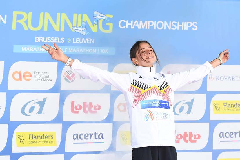 Belgian Chloe Herbiet celebrates on the podium after winning the half marathon race at European Running Championships, in Leuven, Saturday 12 April 2025. BELGA PHOTO JILL DELSAUX